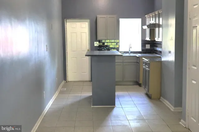 a kitchen with kitchen island granite countertop a refrigerator and a stove