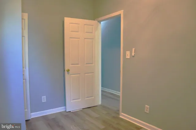 an empty room with wooden floor and closet