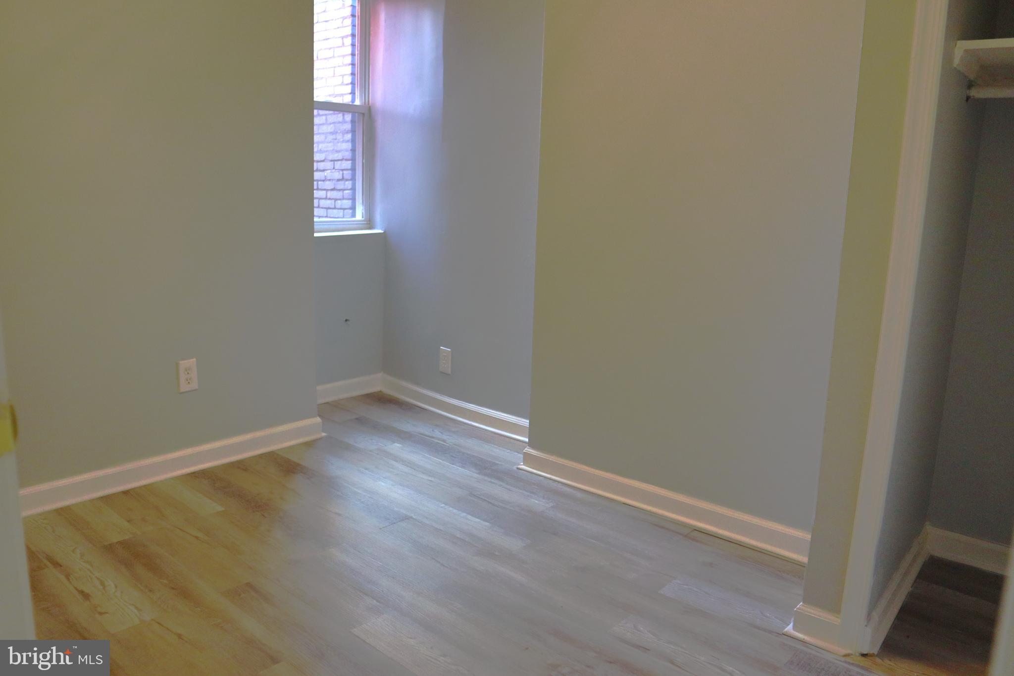 2011 Hollins Street Baltimore, MD 21223 - Photo 8 of 15 an empty room with wooden floor and windows