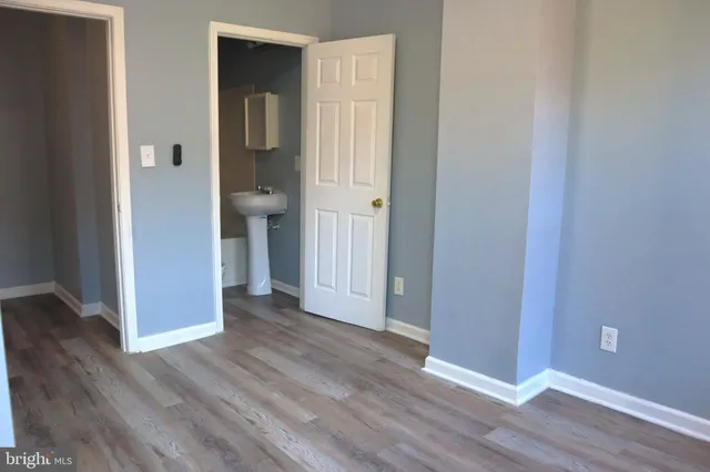 an empty room with wooden floor and closet