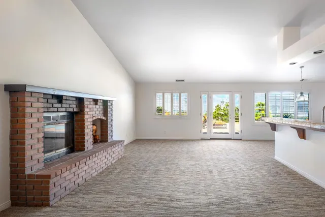 a view of an empty room with window and fire place