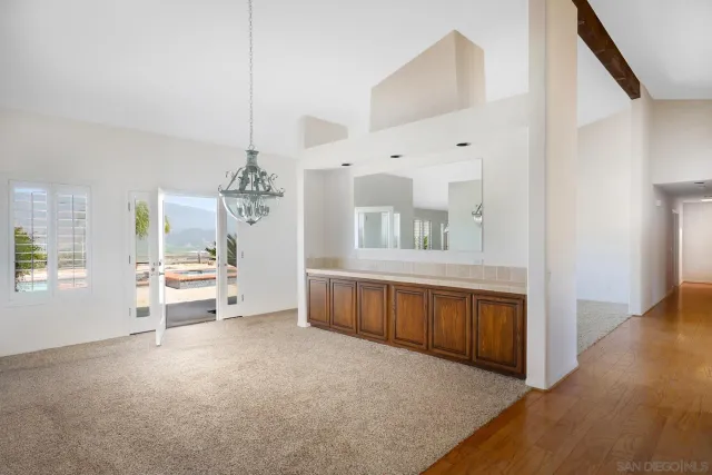 an empty room with windows and fireplace