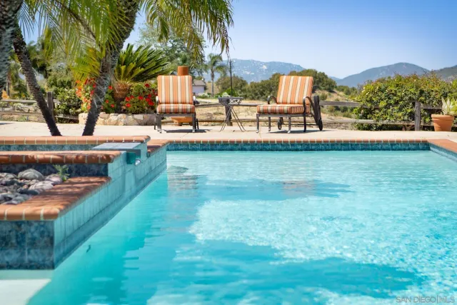 a view of a house with a yard and a large tree