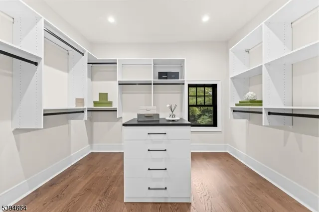 a kitchen with white cabinets and wooden floor