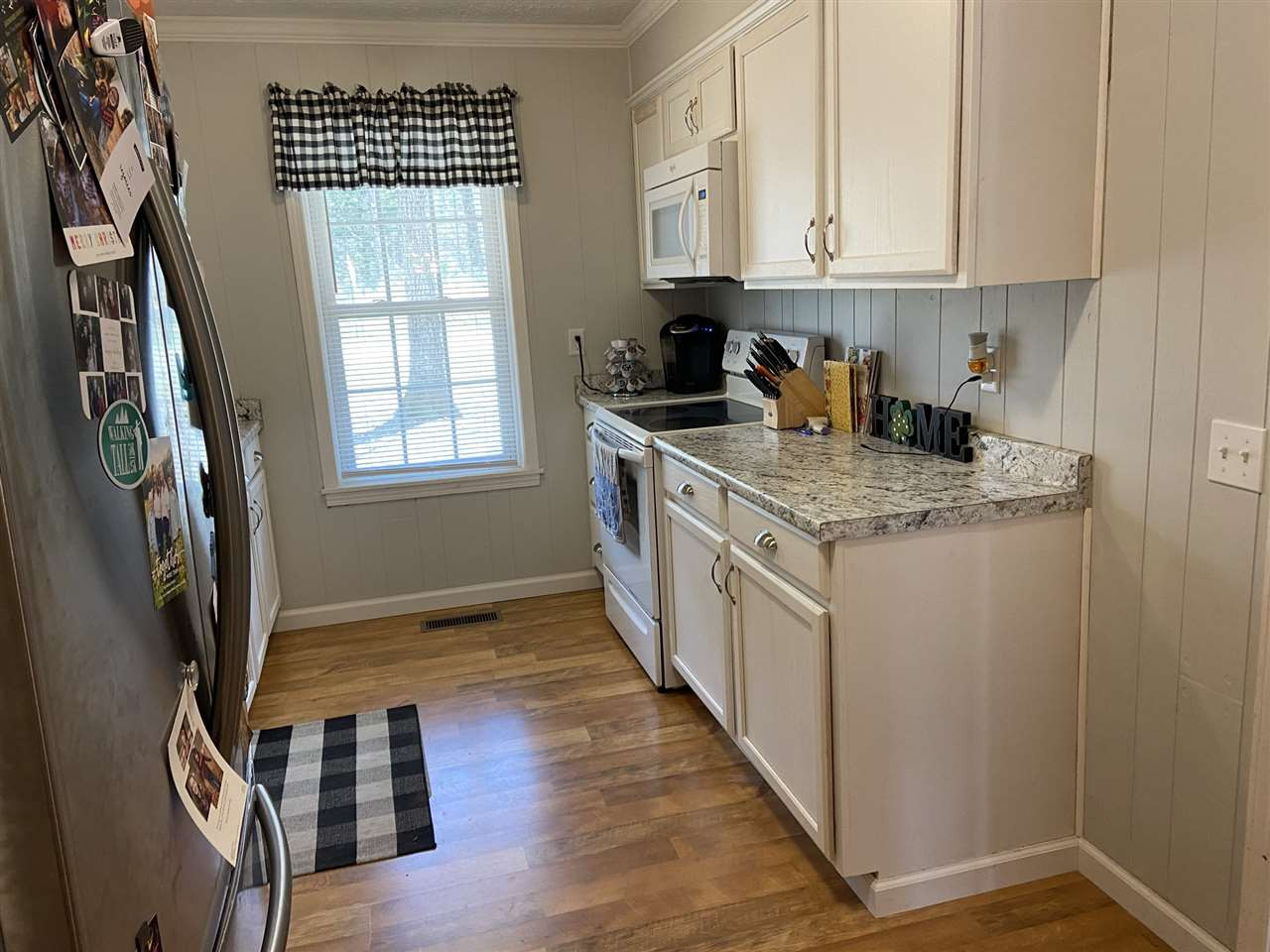 100 Montezuma Road Henderson, TN 38340 - Photo 8 of 20 a kitchen with stainless steel appliances granite countertop a stove a sink dishwasher and white cabinets with wooden floor