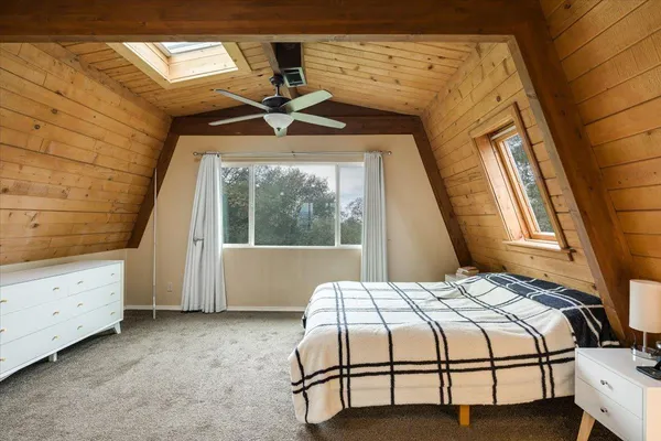 a bedroom with a bed a table and painting on the wall