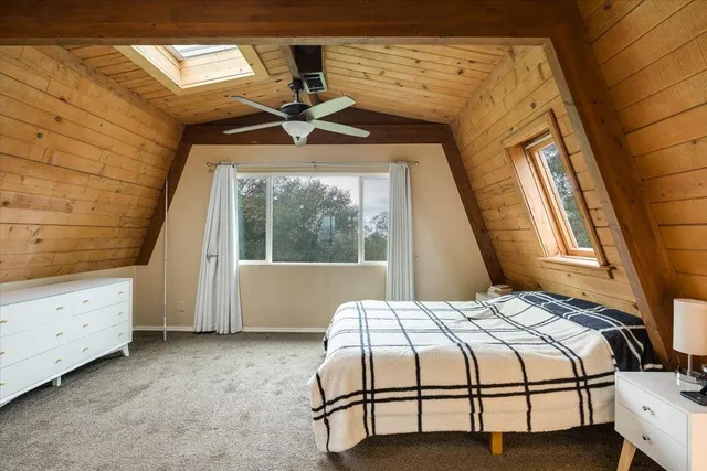 a bedroom with a bed a table and painting on the wall