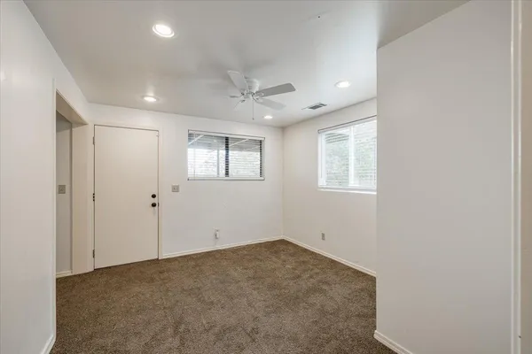 an empty room with chandelier fan