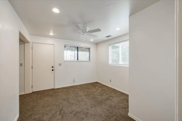 an empty room with chandelier fan