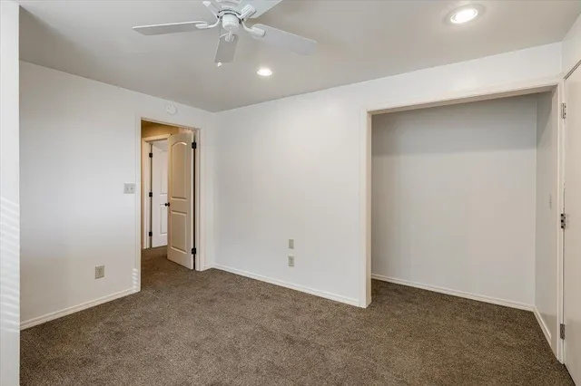 a bathroom with a granite countertop sink toilet and mirror
