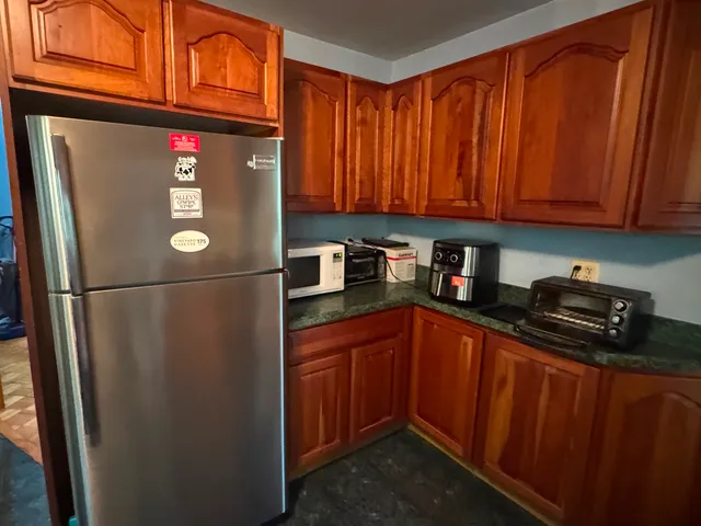 a kitchen with stainless steel appliances granite countertop a refrigerator and a sink