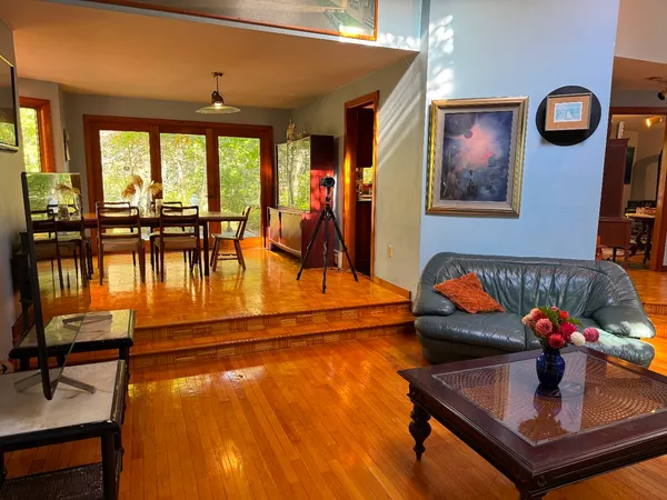 a living room with furniture pool table and view of kitchen