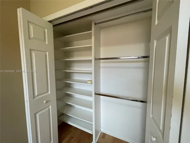 a view of walk in closet with empty racks