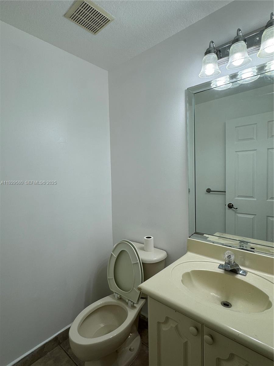 8507 Northwest 140th Terrace, Unit 801 Miami Lakes, FL 33016 - Photo 27 of 42 a bathroom with a sink vanity mirror and toilet
