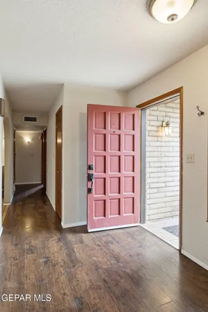 a view of an empty room with window and wooden floor