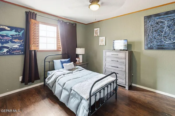 a bedroom with a bed a dresser and painting on the wall
