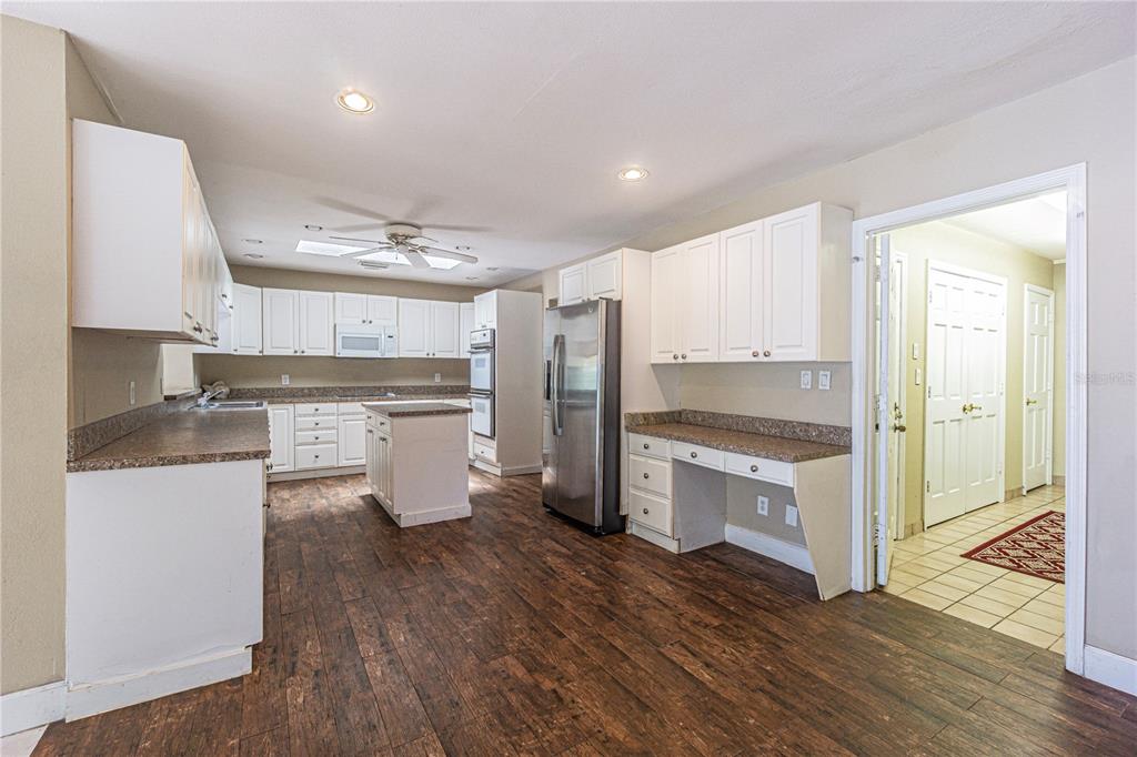 18129 Crawley Road Odessa, FL 33556 - Photo 16 of 38 a kitchen with a refrigerator and white cabinets