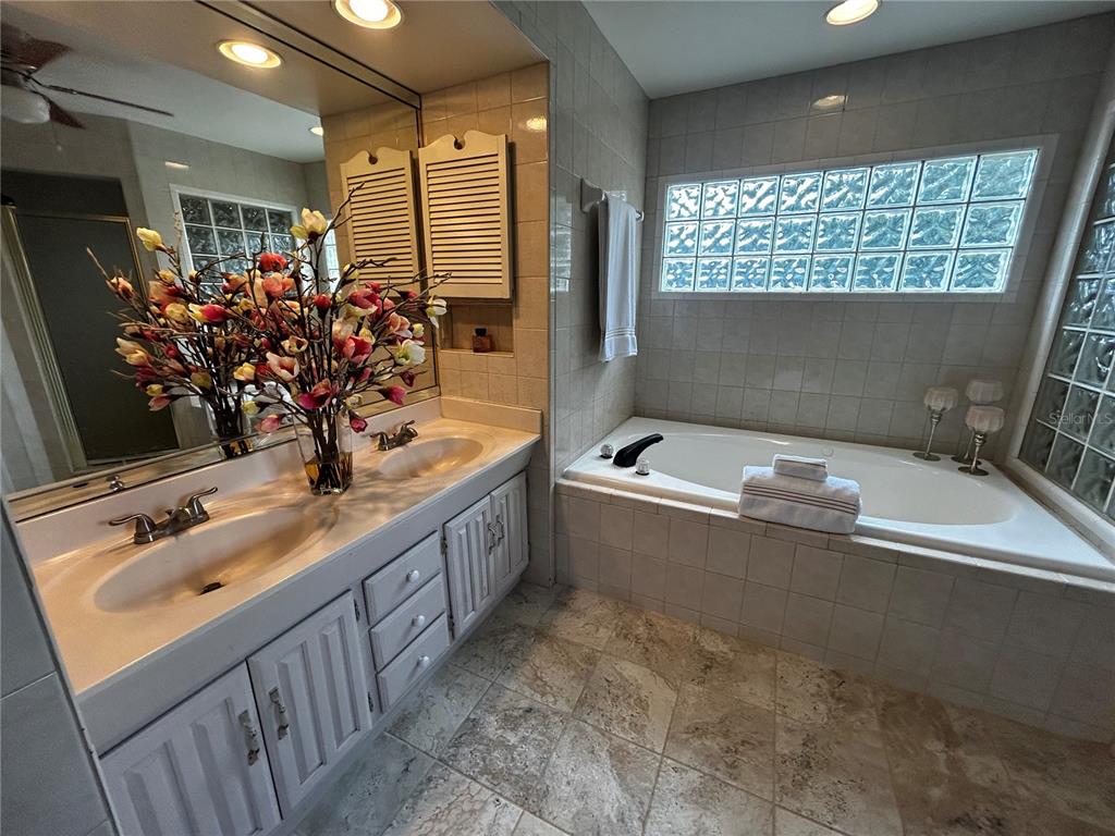 18129 Crawley Road Odessa, FL 33556 - Photo 24 of 38 a bathroom with a tub sink and mirror