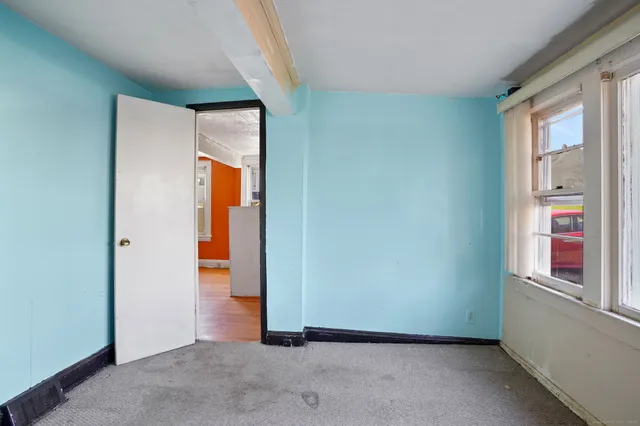 a view of an empty room with closet and a window
