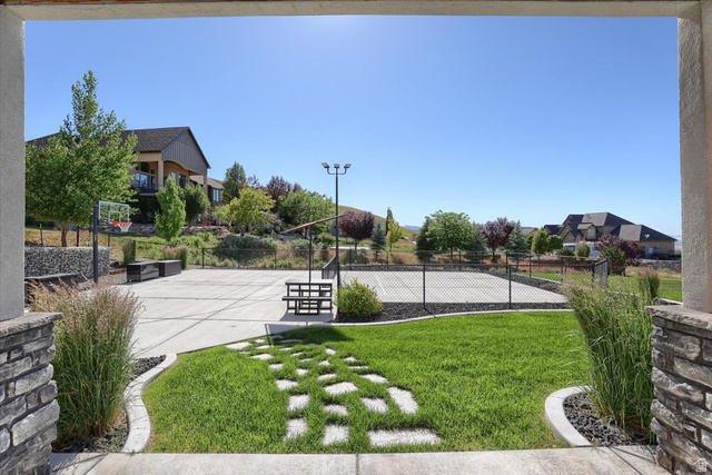 828 South Deer Road Tooele, UT 84074 - Photo 41 of 51 Expansive backyard featuring a manicured lawn, a concrete sport court with basketball hoop, and a fenced tennis court