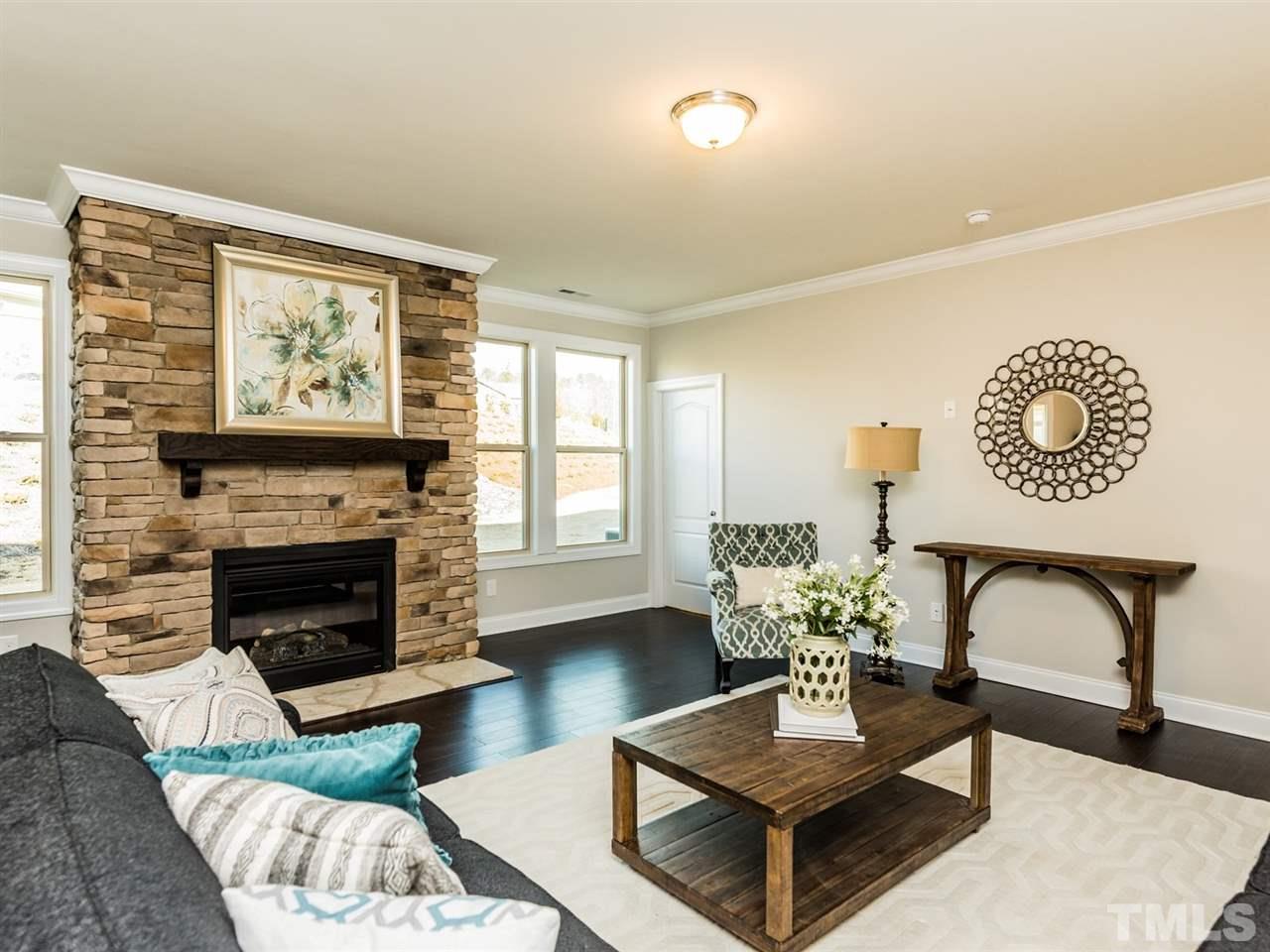 1809 Capstone Drive Durham, NC 27713 - Photo 16 of 25 a living room with furniture a fireplace and wall paintings