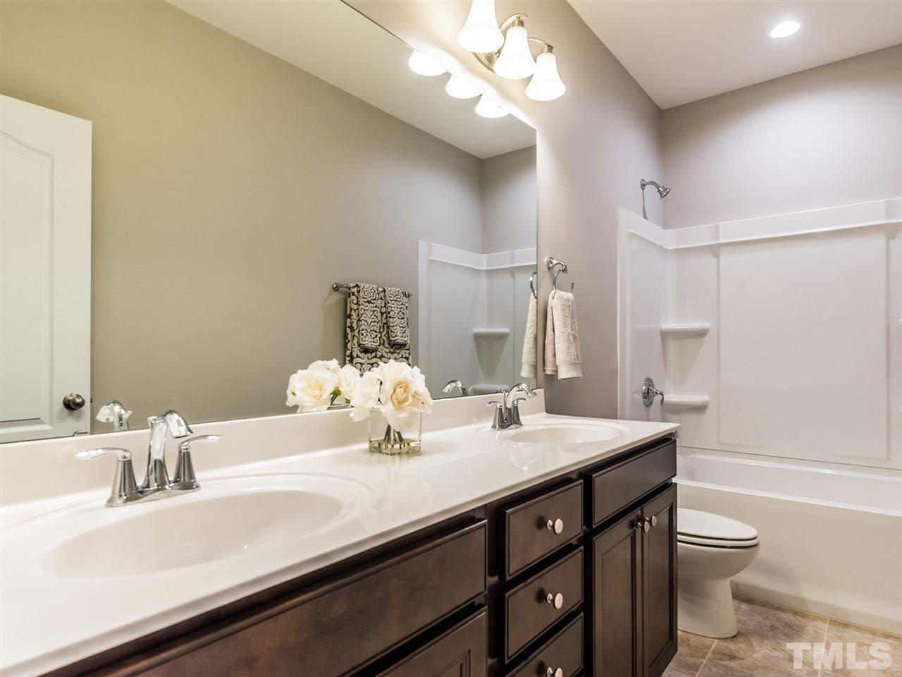 1809 Capstone Drive Durham, NC 27713 - Photo 17 of 25 a bathroom with a sink a toilet and a large mirror
