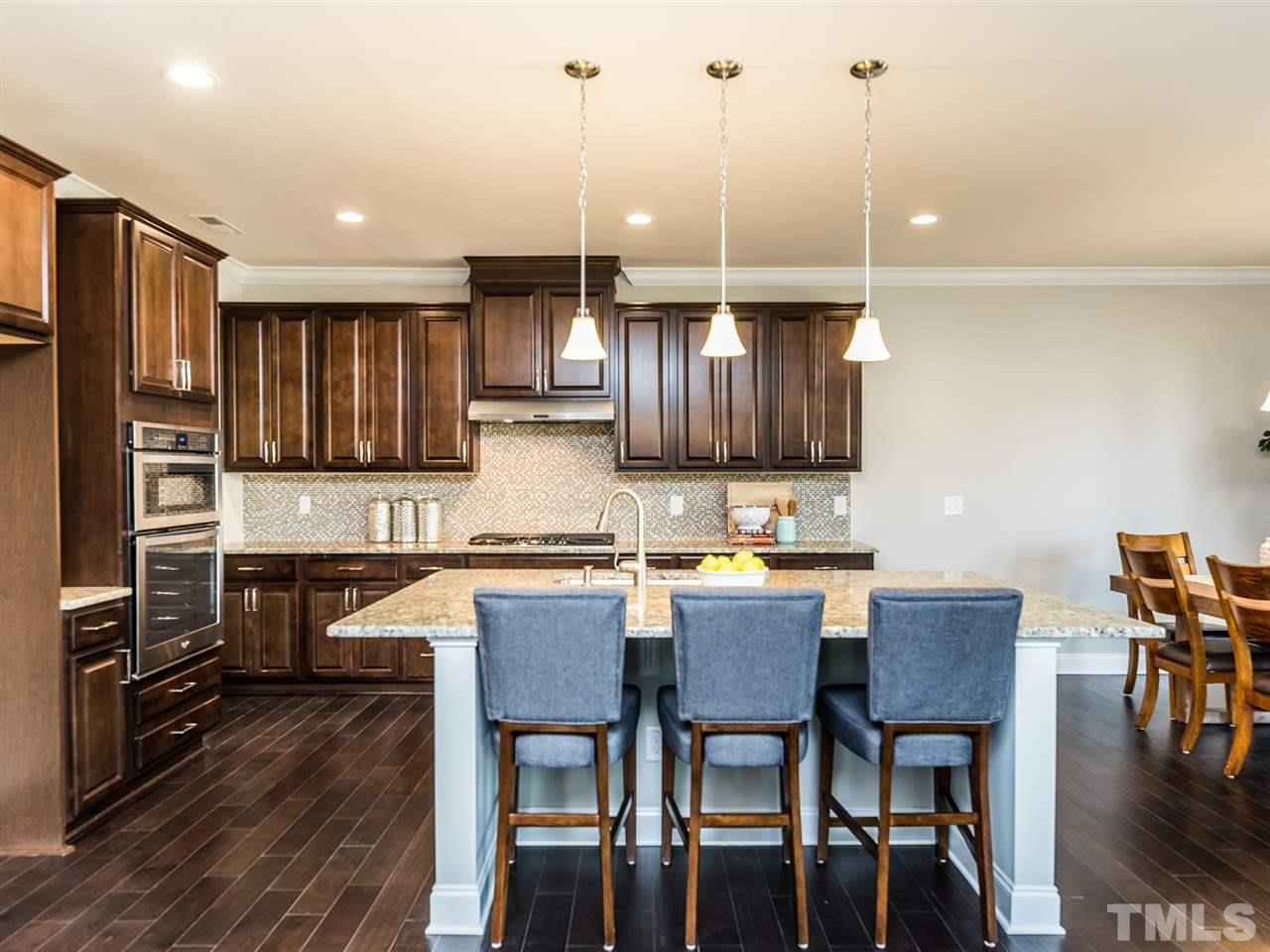 1809 Capstone Drive Durham, NC 27713 - Photo 9 of 25 a kitchen with granite countertop a table chairs microwave and cabinets