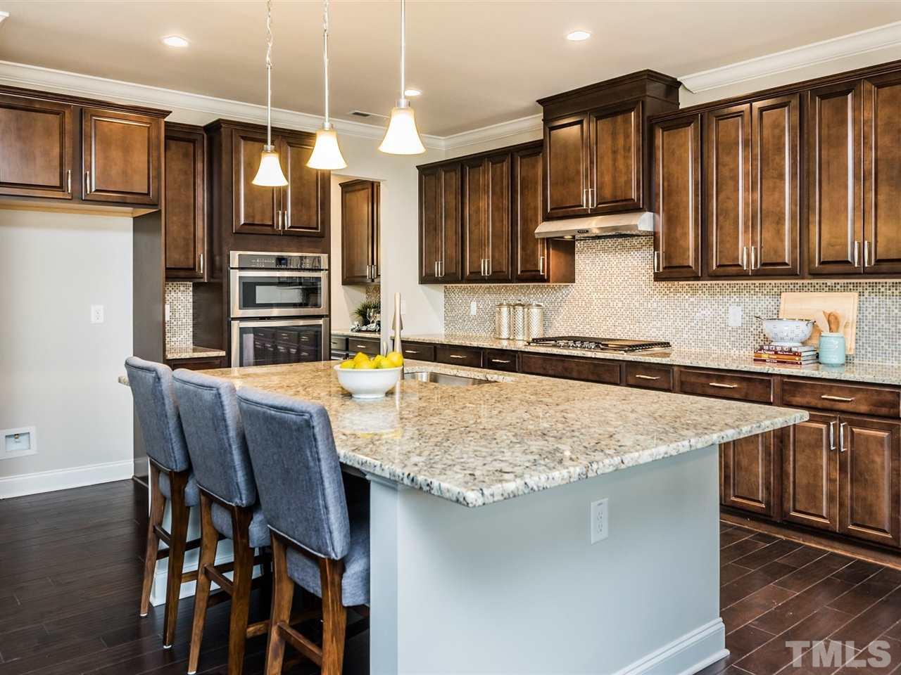 1809 Capstone Drive Durham, NC 27713 - Photo 10 of 25 a kitchen with stainless steel appliances granite countertop a sink a stove a microwave a center island and chairs