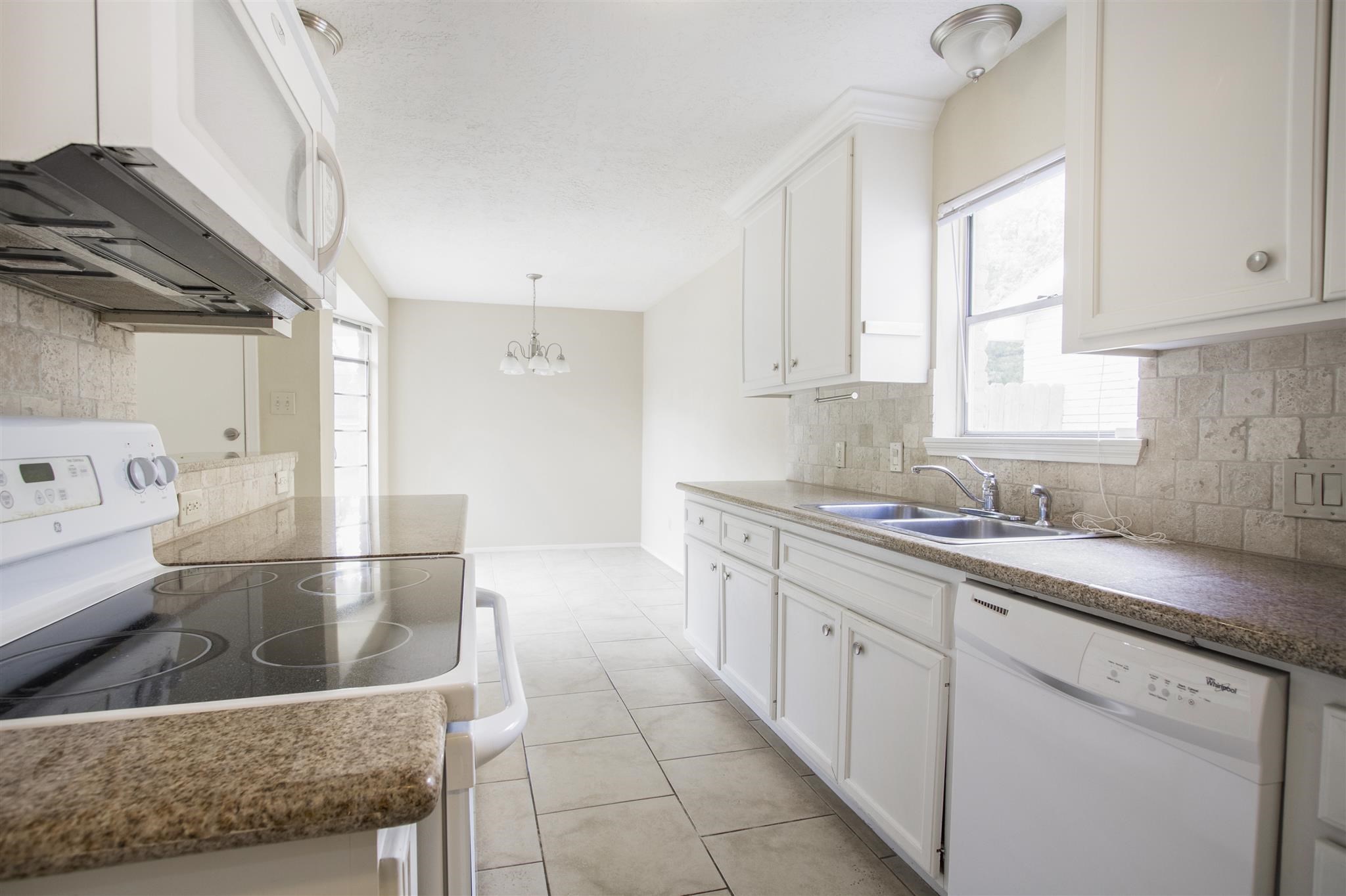 6019 Spellman Road Houston, TX 77096 - Photo 11 of 19 a kitchen with granite countertop a sink a window and stainless steel appliances