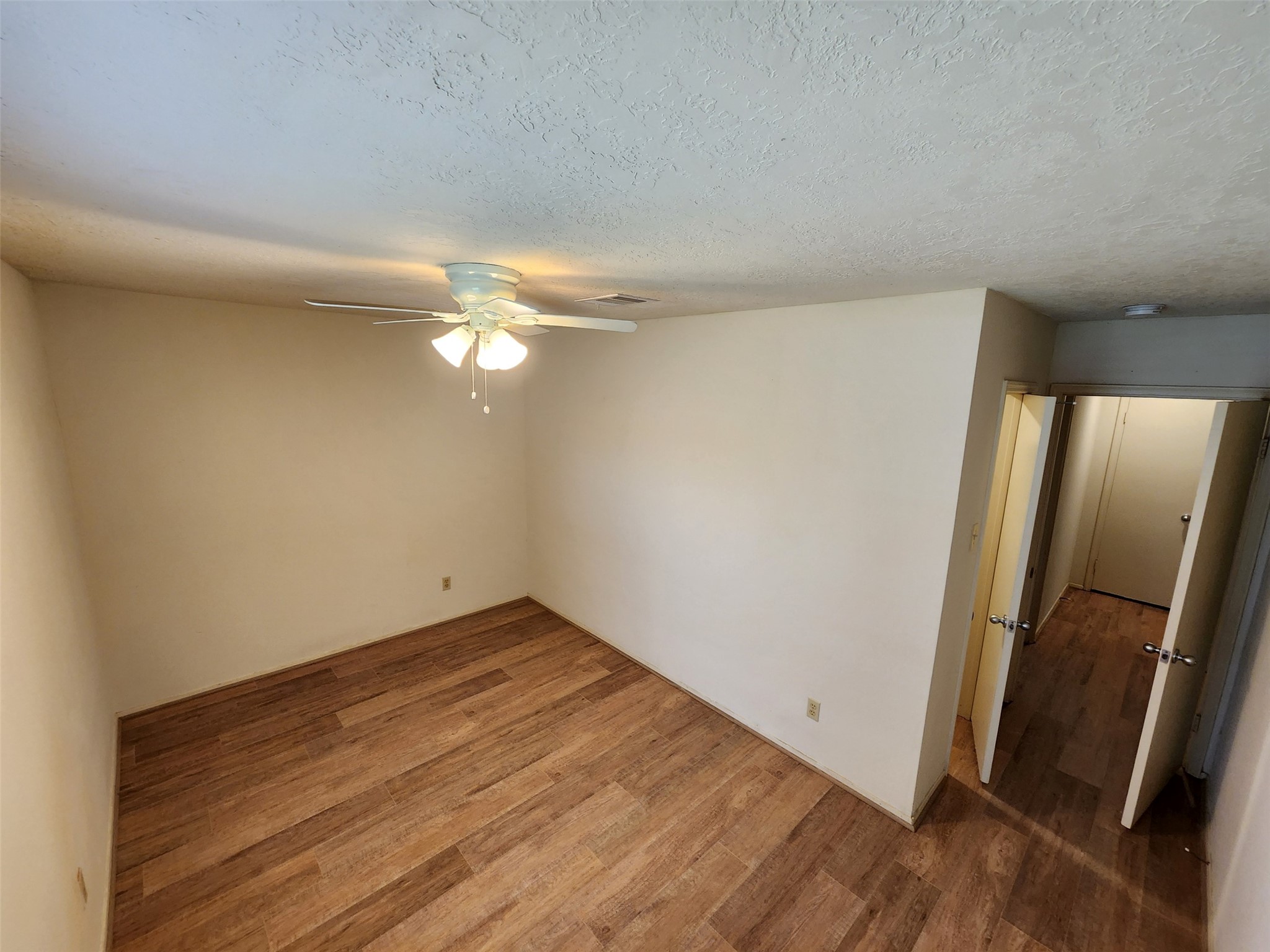 6019 Spellman Road Houston, TX 77096 - Photo 12 of 19 an empty room with wooden floor and mirror