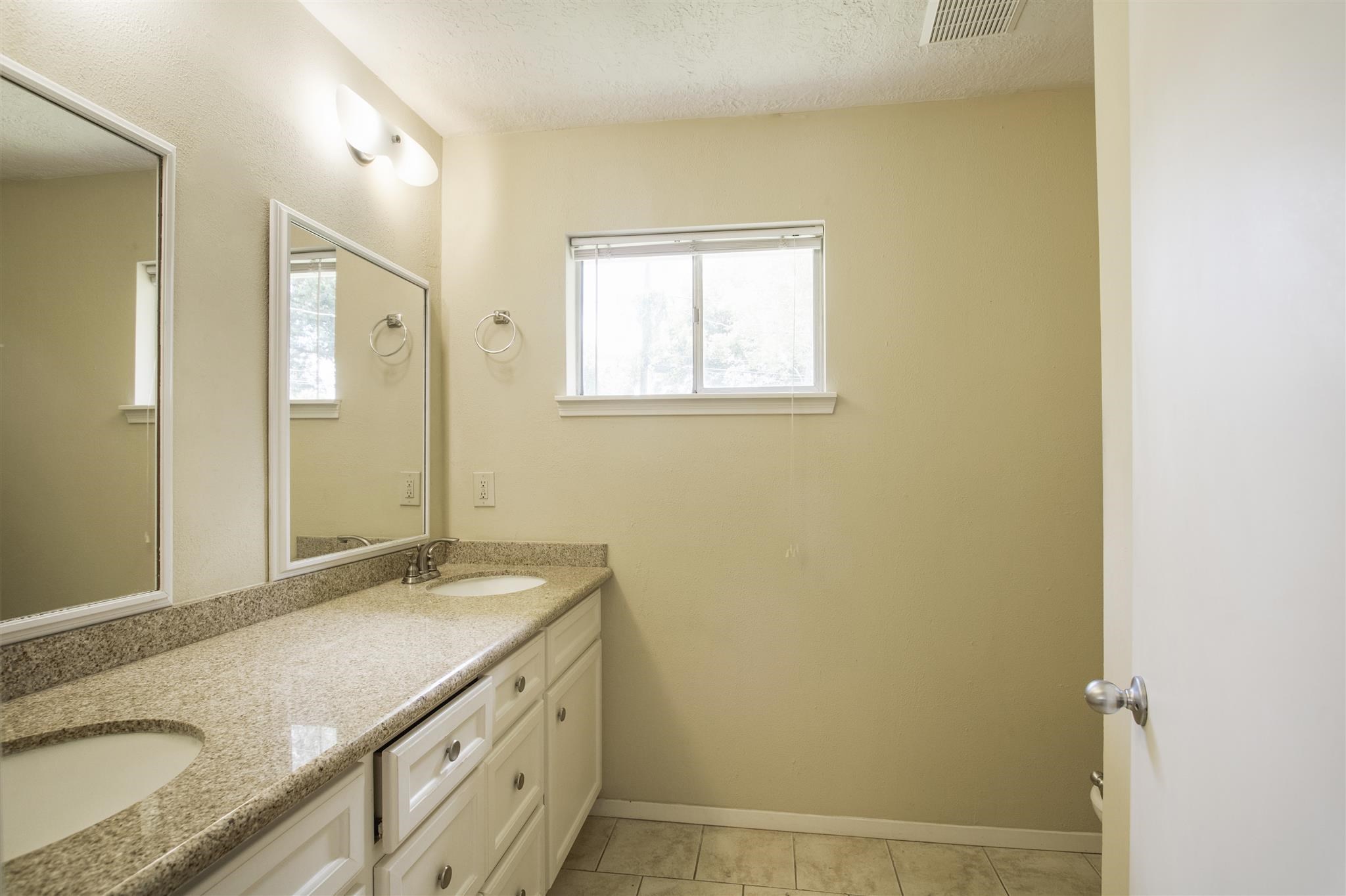 6019 Spellman Road Houston, TX 77096 - Photo 13 of 19 a bathroom with a granite countertop sink and a mirror