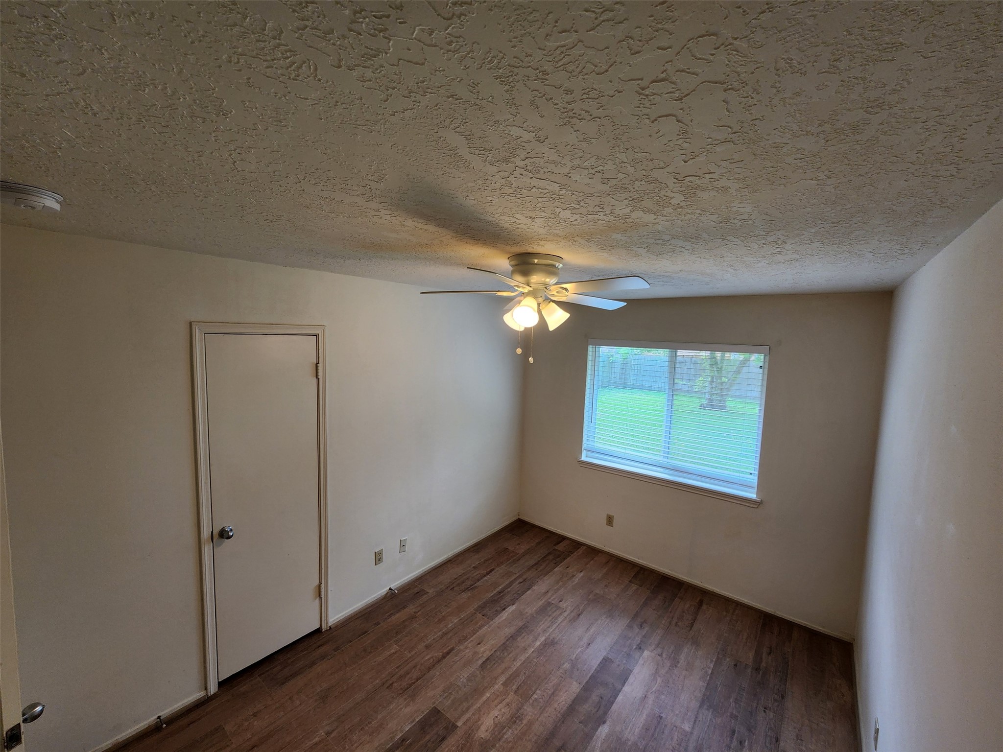 6019 Spellman Road Houston, TX 77096 - Photo 16 of 19 an empty room with wooden floor chandelier and windows