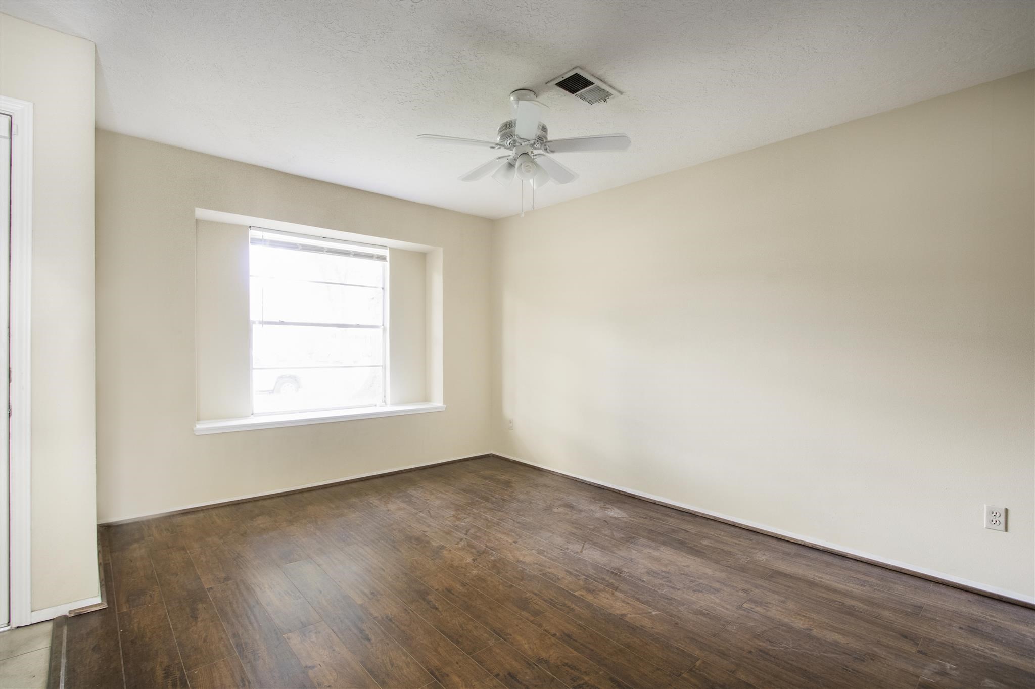 6019 Spellman Road Houston, TX 77096 - Photo 5 of 19 an empty room with a window and a ceiling fan