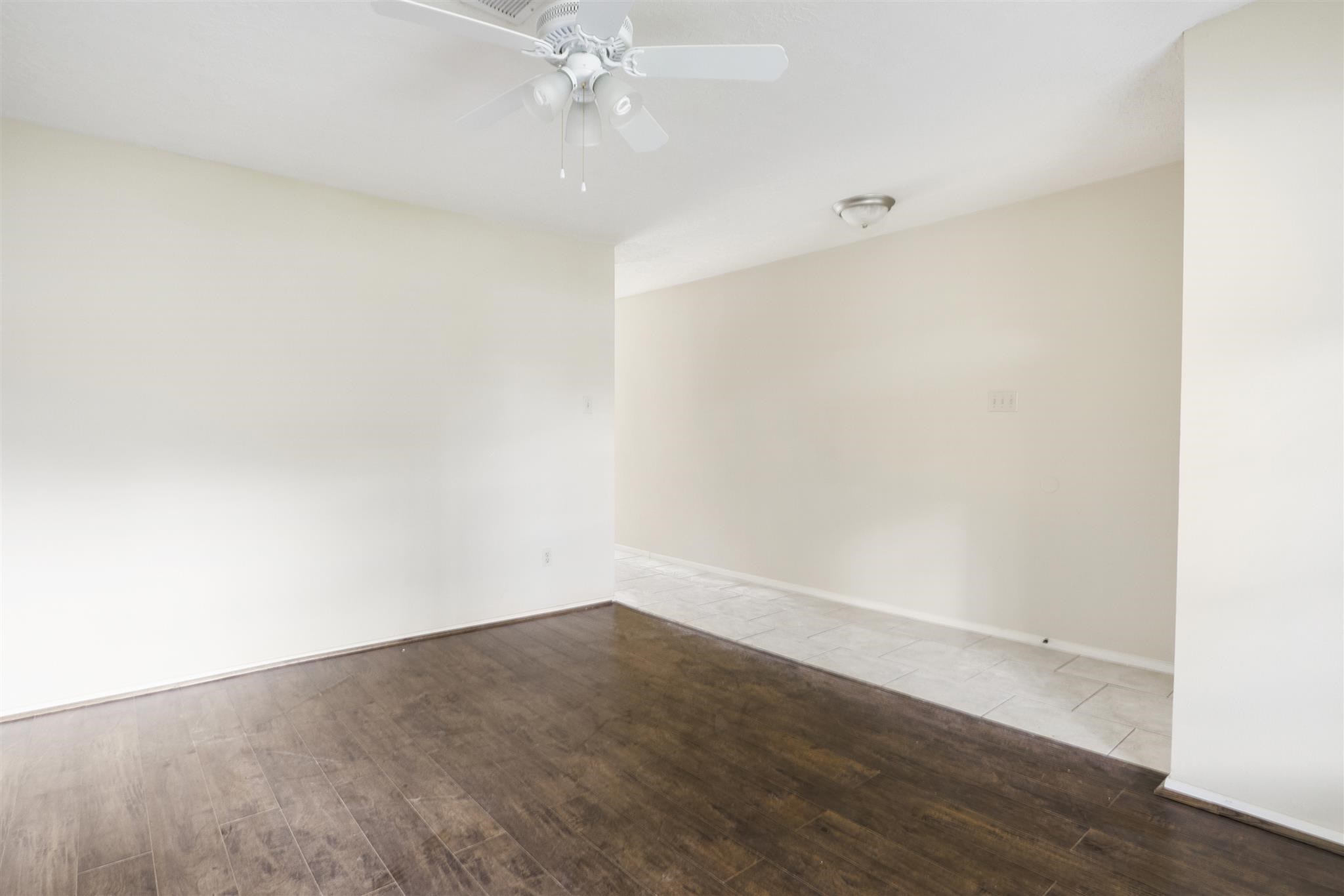 6019 Spellman Road Houston, TX 77096 - Photo 6 of 19 an empty room with wooden floor and fan