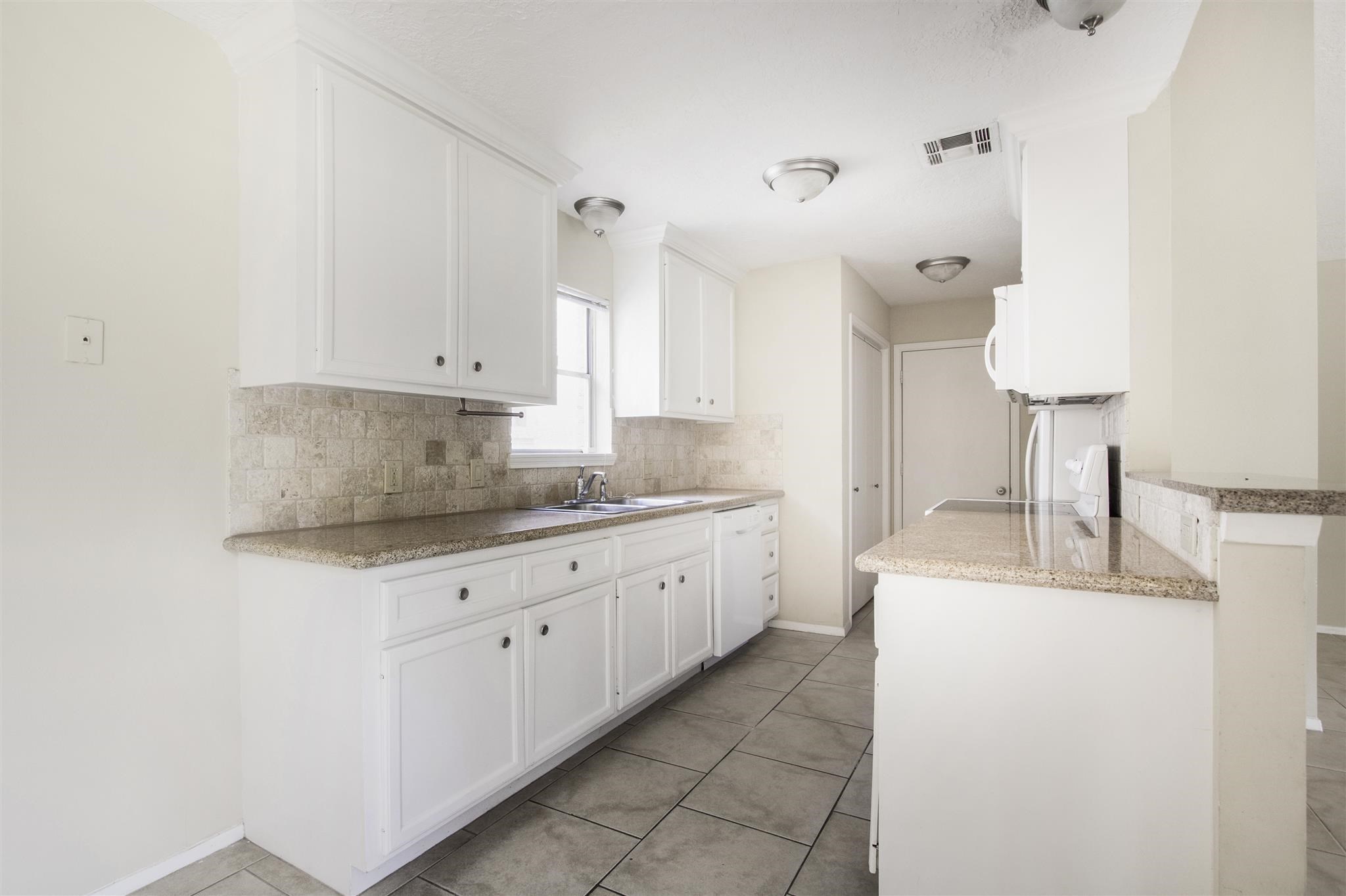 6019 Spellman Road Houston, TX 77096 - Photo 10 of 19 a kitchen with granite countertop a sink a stove and a granite counter tops