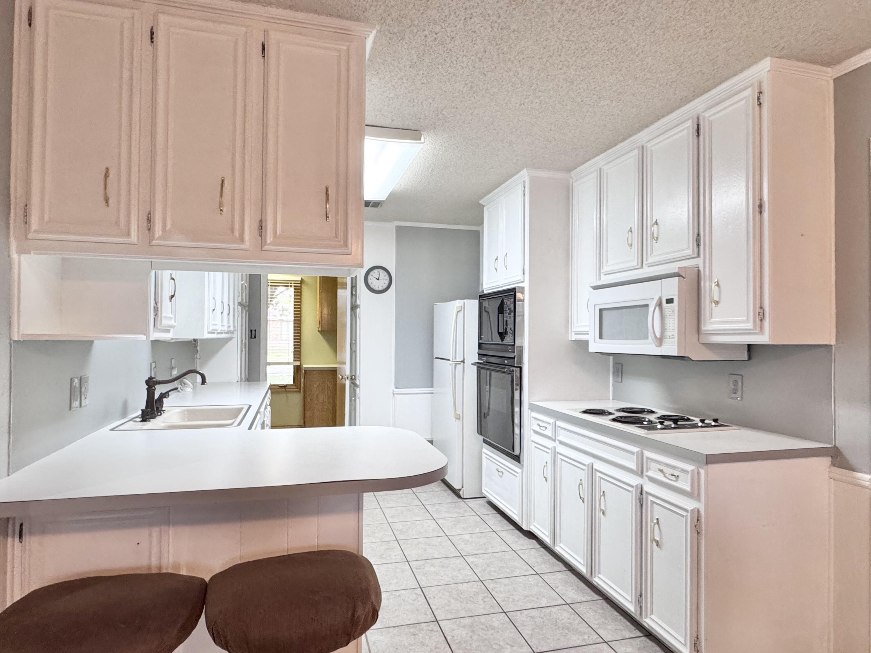 5617 87th Street Lubbock, TX 79424 - Photo 14 of 22 a kitchen with stainless steel appliances granite countertop a sink a stove a refrigerator and cabinets