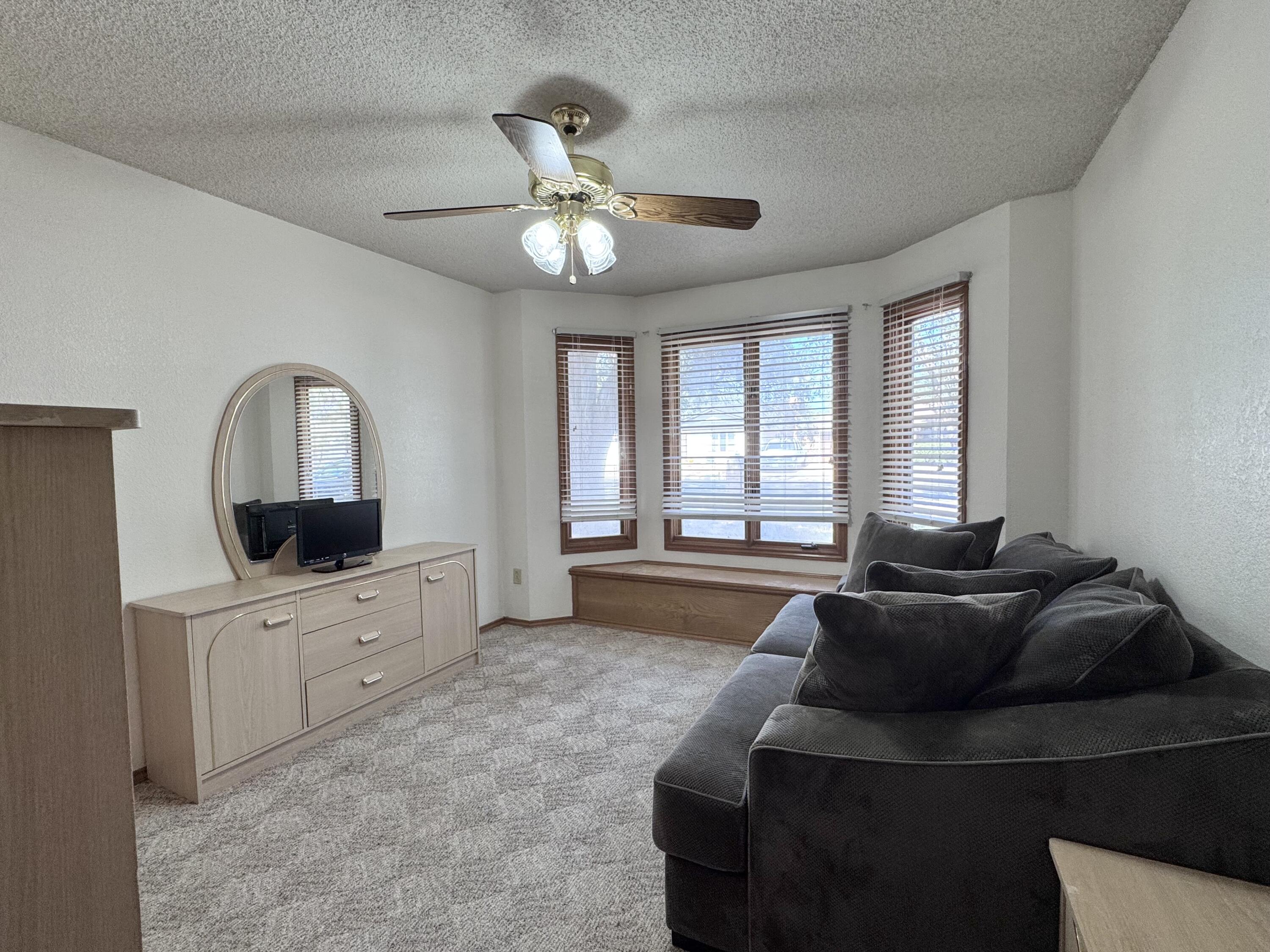 5617 87th Street Lubbock, TX 79424 - Photo 16 of 22 a living room with furniture a window and a flat screen tv