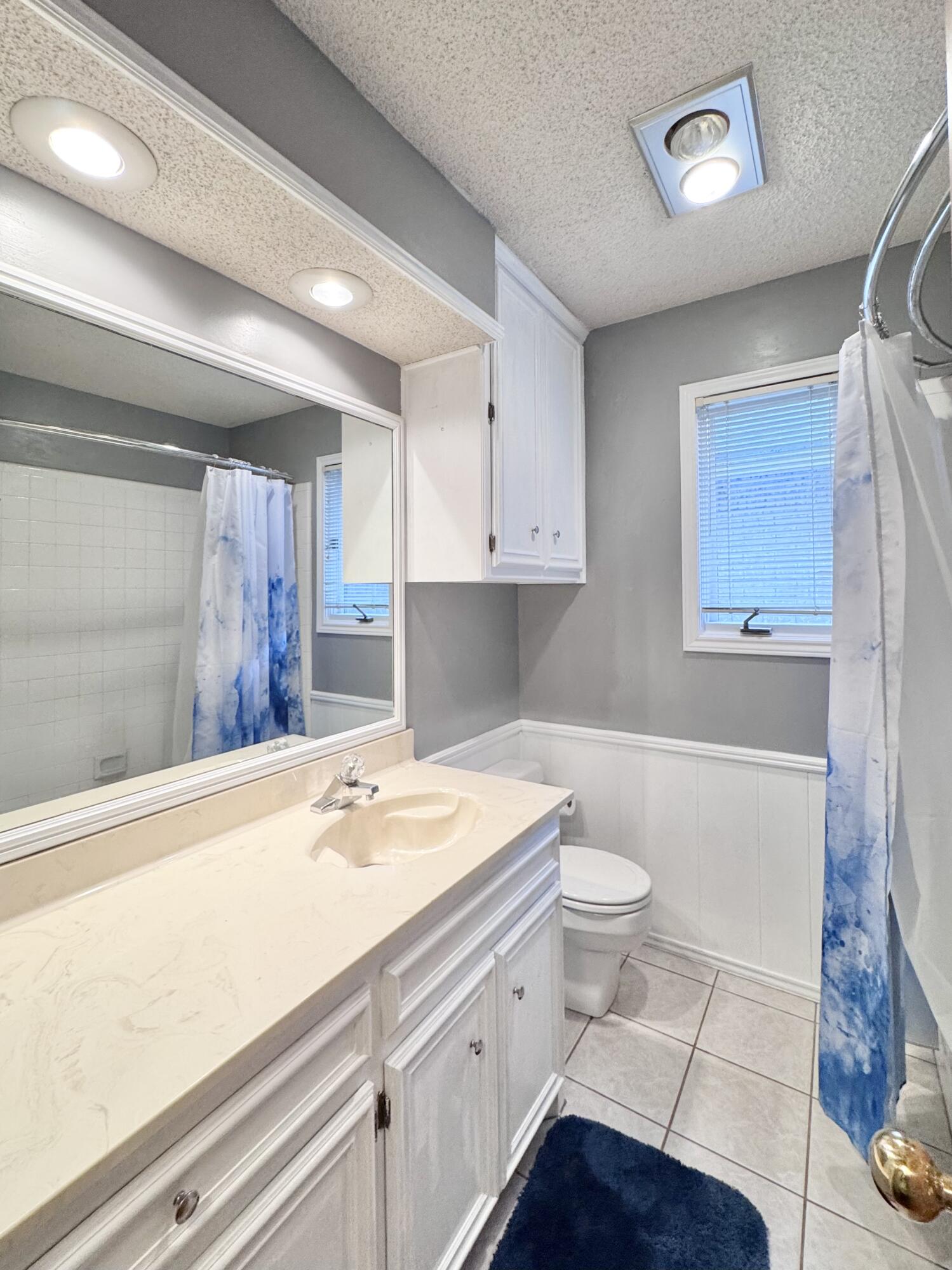5617 87th Street Lubbock, TX 79424 - Photo 17 of 22 a bathroom with a sink a toilet and a shower