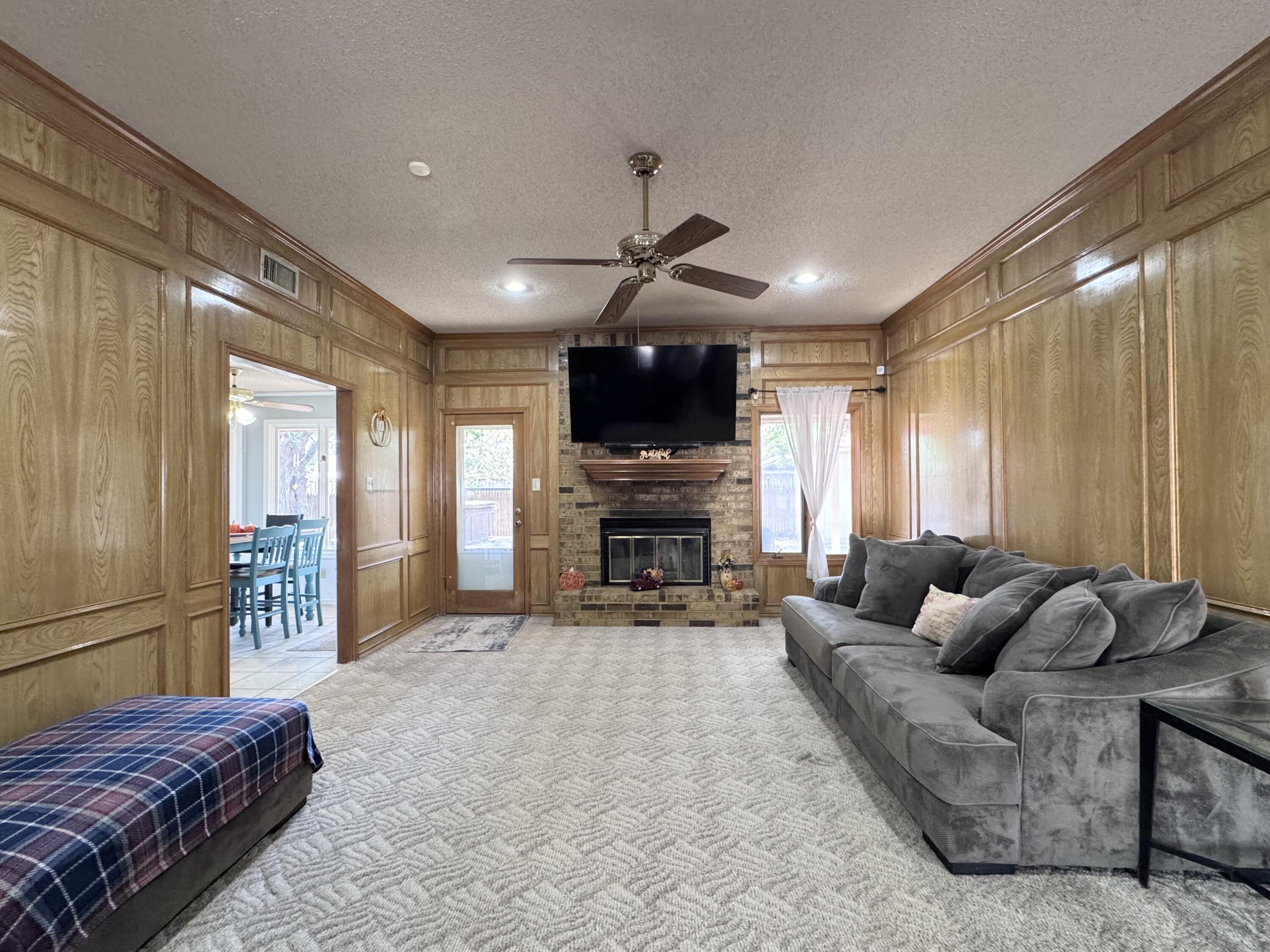 5617 87th Street Lubbock, TX 79424 - Photo 6 of 22 a living room with furniture a fireplace and a flat screen tv
