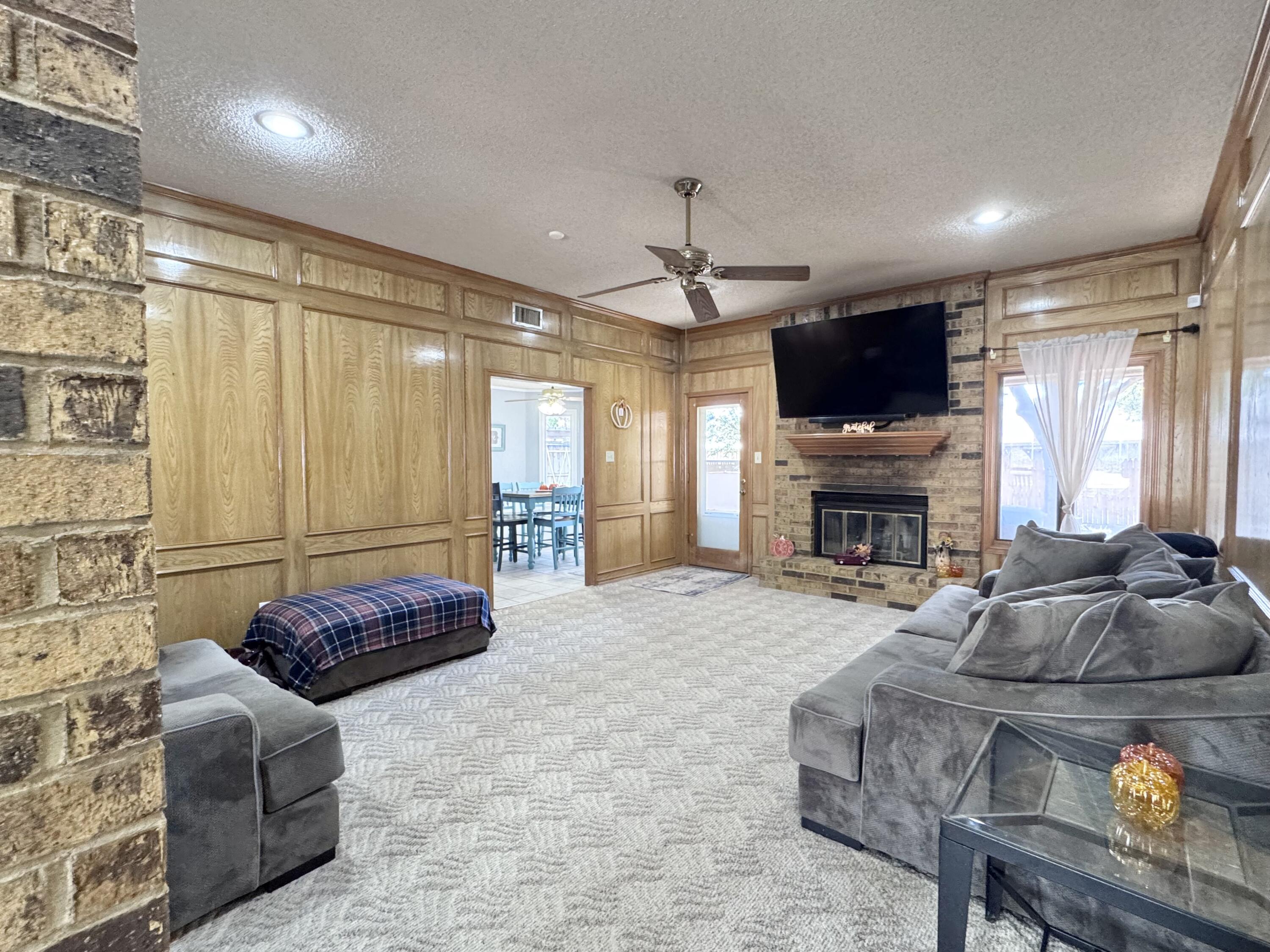 5617 87th Street Lubbock, TX 79424 - Photo 7 of 22 a living room with furniture a fireplace and a flat screen tv
