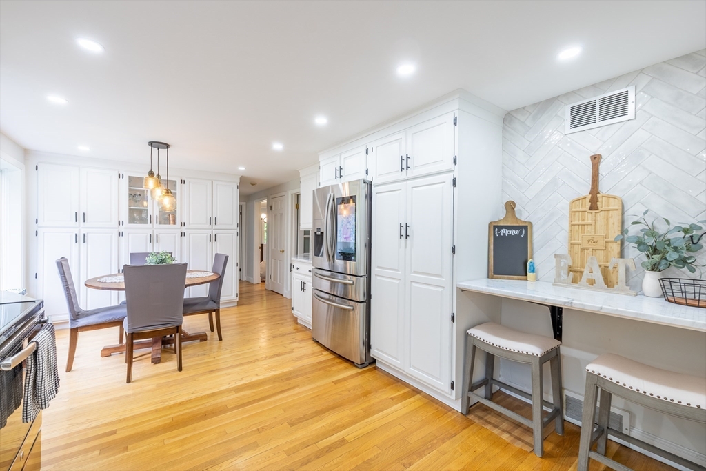26 Roundtop Road Boxford, MA 01921 - Photo 8 of 42 a kitchen with stainless steel appliances kitchen island granite countertop a table chairs and a refrigerator