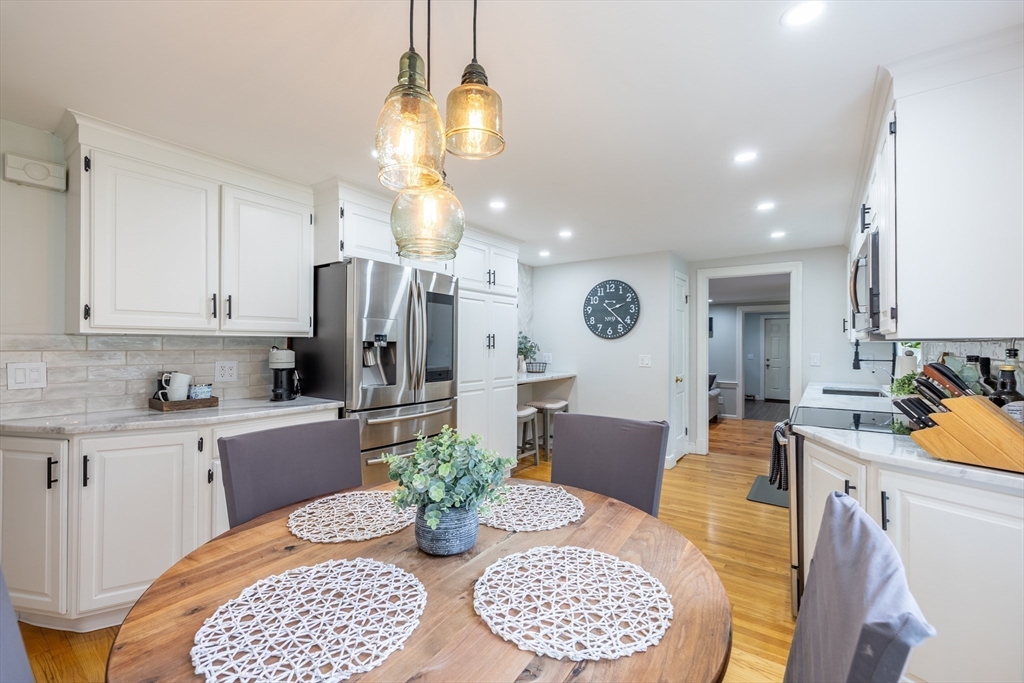 26 Roundtop Road Boxford, MA 01921 - Photo 9 of 42 a kitchen with stainless steel appliances kitchen island granite countertop a dining table and chairs