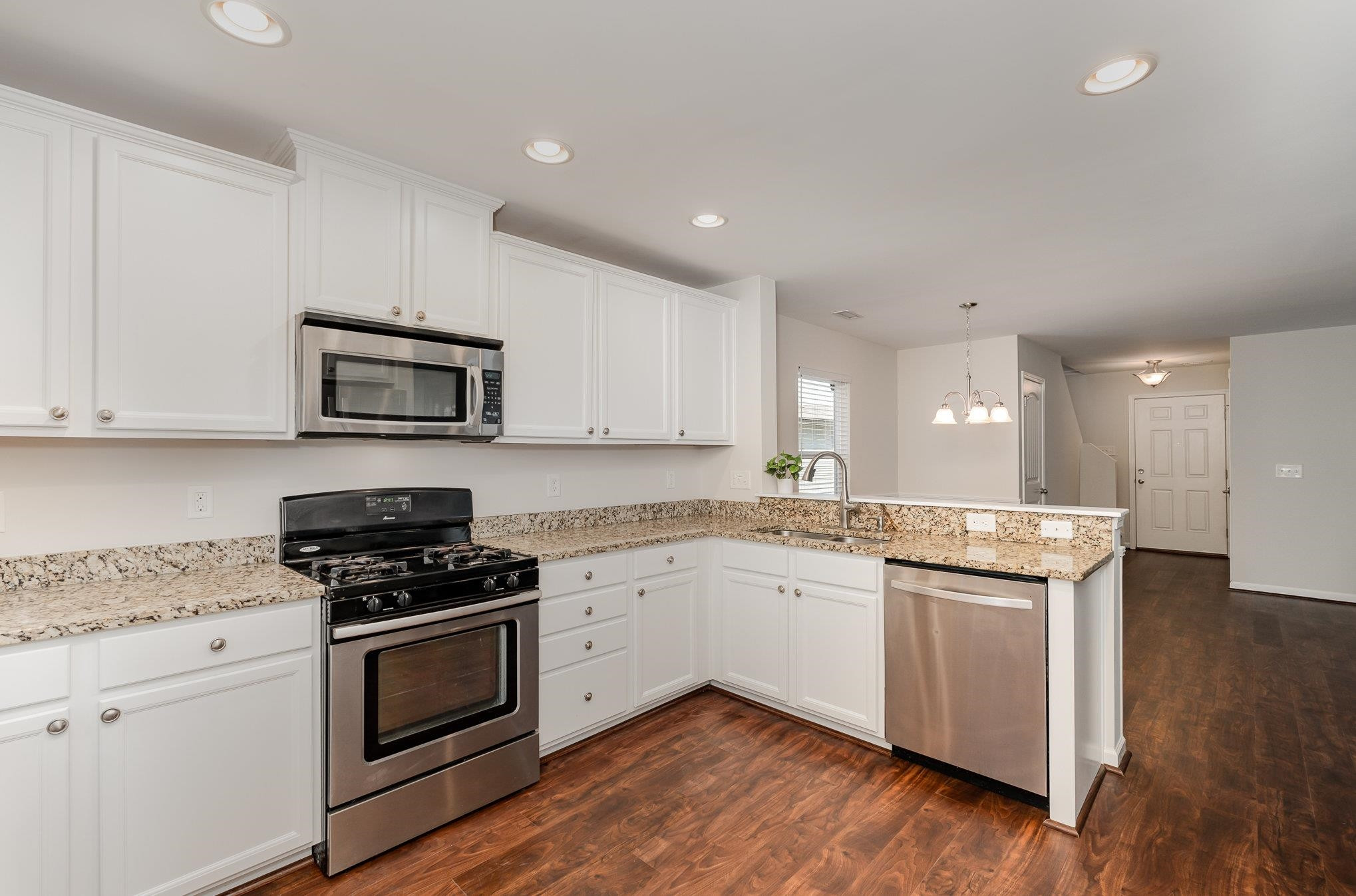 4364 Lyman Avenue Raleigh, NC 27616 - Photo 11 of 28 a kitchen with granite countertop appliances cabinets and a wooden floor