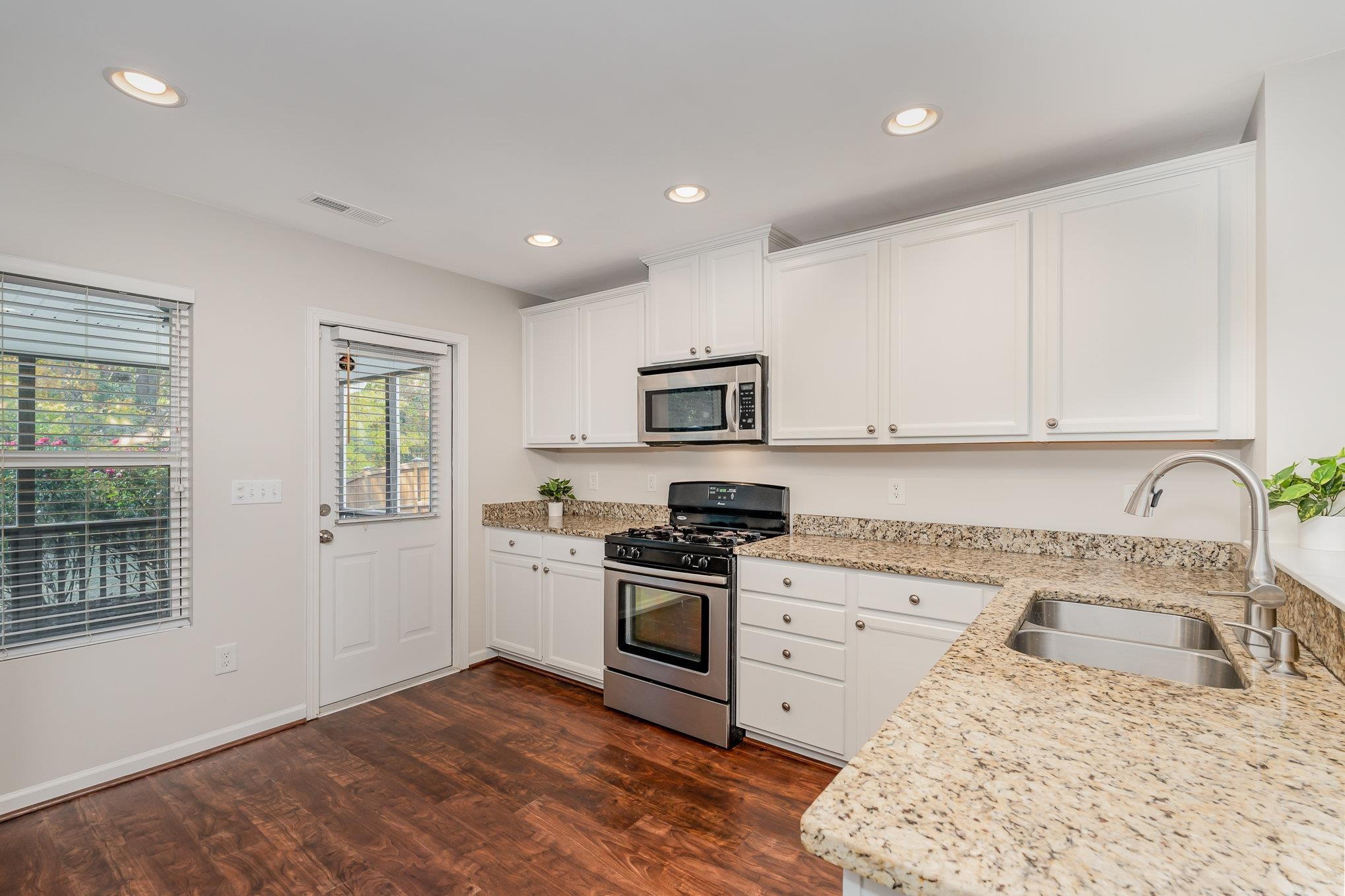 4364 Lyman Avenue Raleigh, NC 27616 - Photo 4 of 28 a kitchen with granite countertop white cabinets and appliances