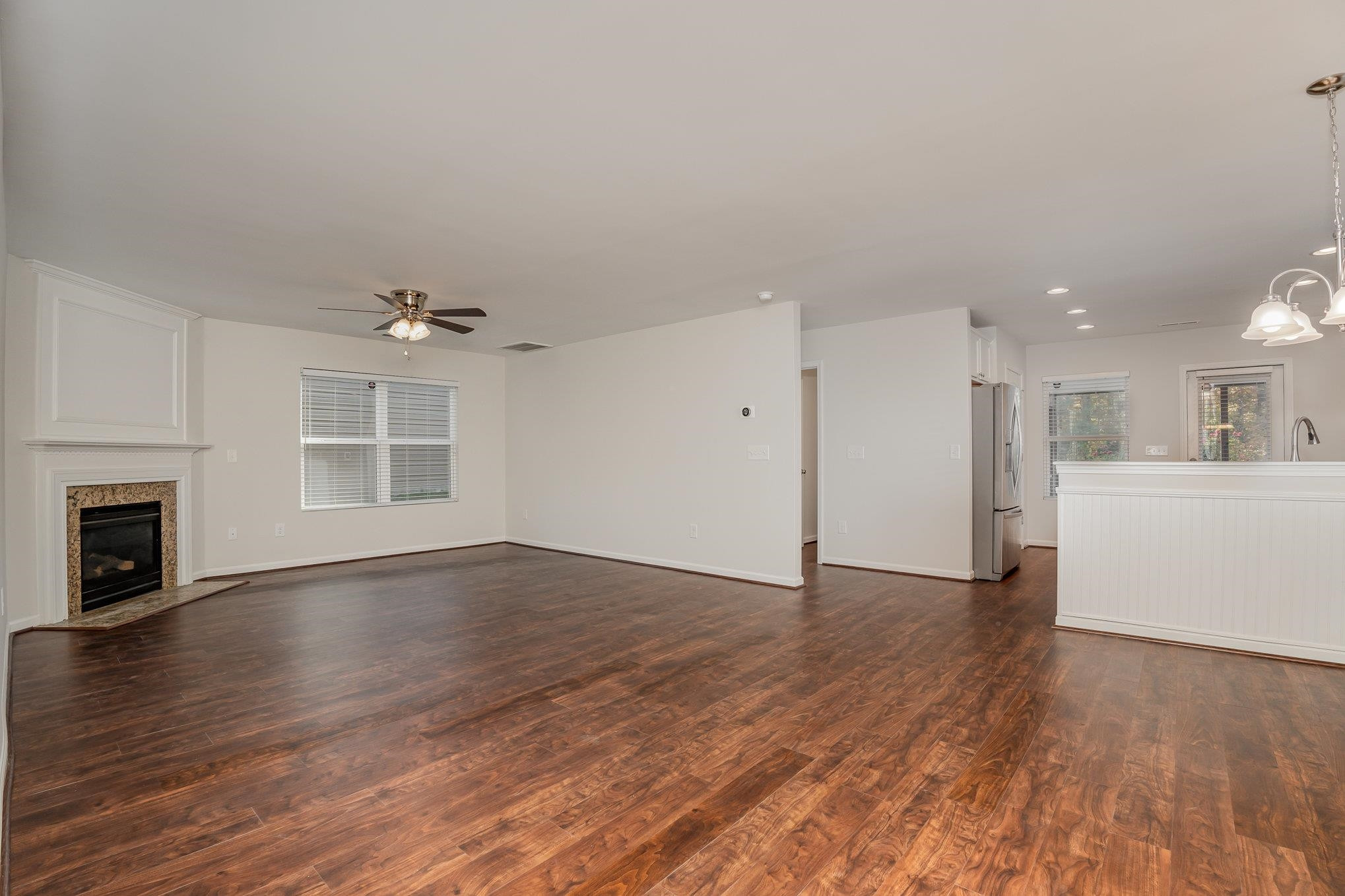 4364 Lyman Avenue Raleigh, NC 27616 - Photo 8 of 28 a view of an empty room with wooden floor and a kitchen
