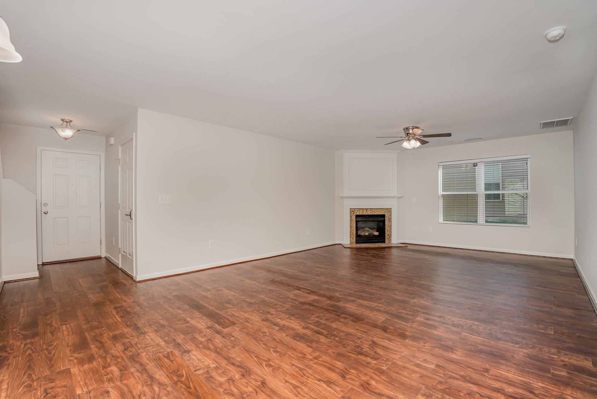 4364 Lyman Avenue Raleigh, NC 27616 - Photo 9 of 28 a view of an empty room with wooden floor and a window