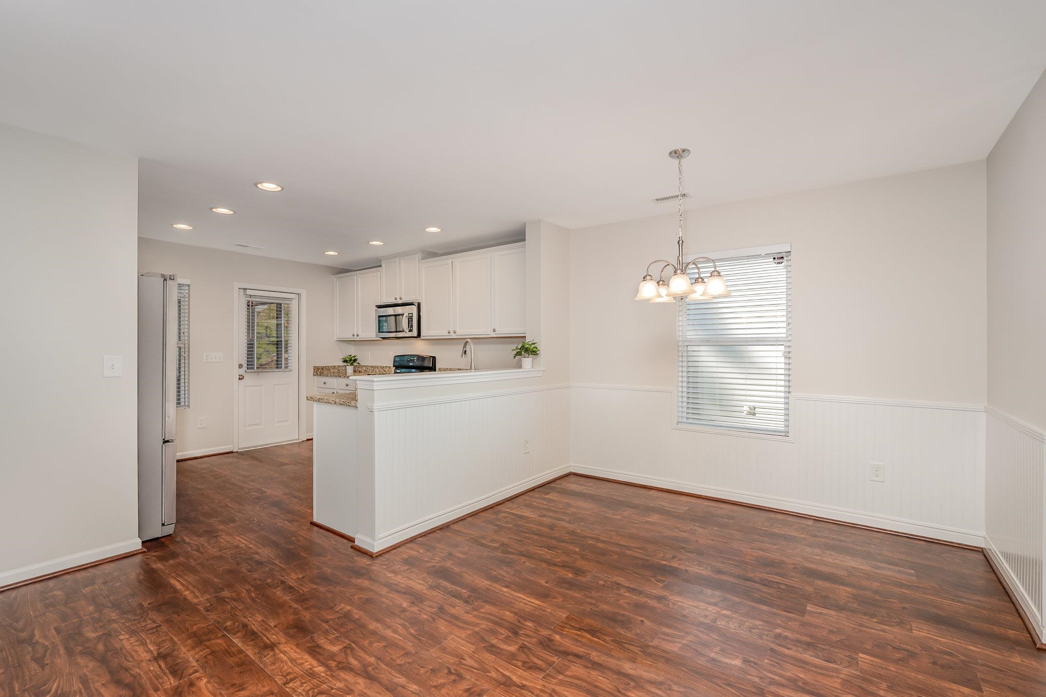 4364 Lyman Avenue Raleigh, NC 27616 - Photo 10 of 28 a view of a kitchen with wooden floor and windows