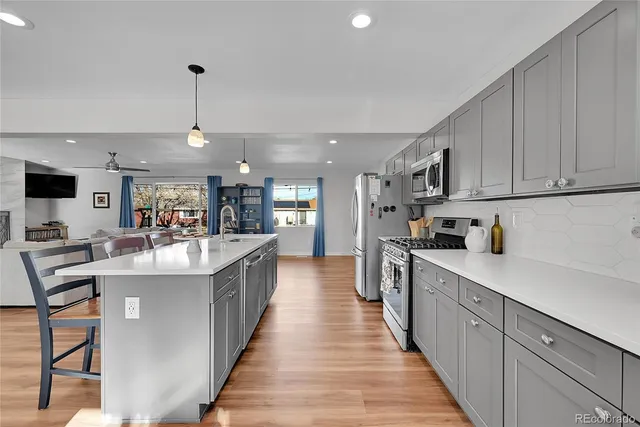 a large kitchen with stainless steel appliances lots of counter space and a sink