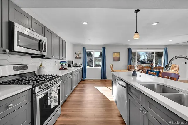 a large kitchen with stainless steel appliances granite countertop a lot of cabinets a stove a sink and dishwasher