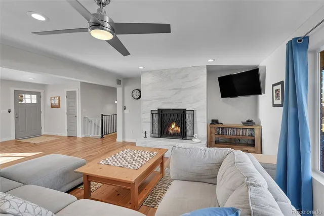 a living room with furniture a flat screen tv and a fireplace